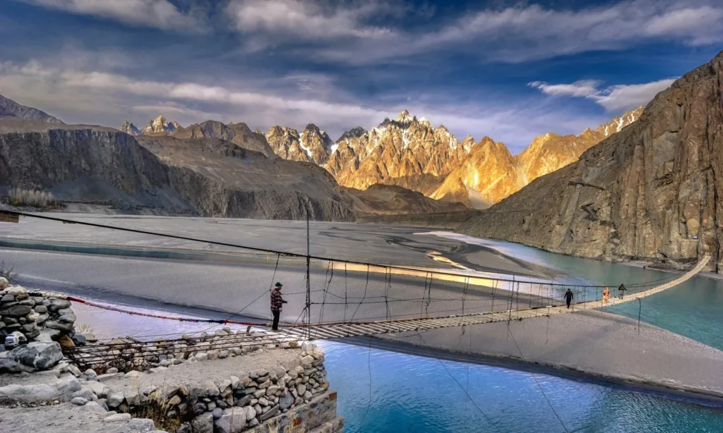 Traveler crossing the Hussaini suspension bridge over the Hunza River in Northern Pakistan