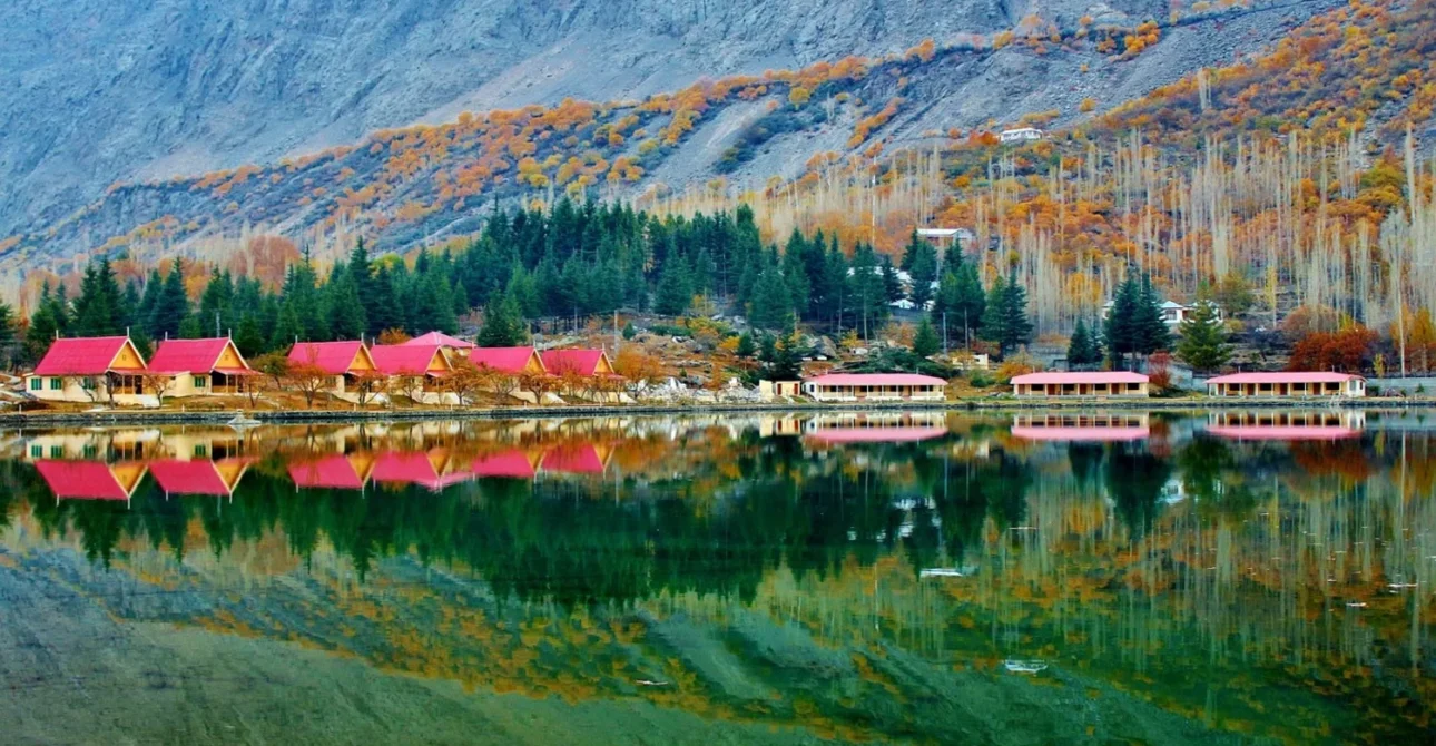 Shangrila (Lower Kachura) Lake with golden reflection of surrounding pines and mountains in Skardu