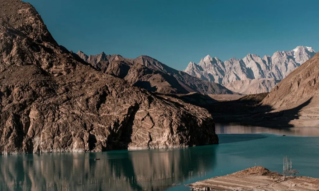 Sunrise over Attabad Lake’s turquoise waters with Karakoram mountains in Hunza Valley